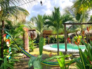 a resort with a swimming pool and palm trees at Sunrise El Paredón in El Paredón Buena Vista