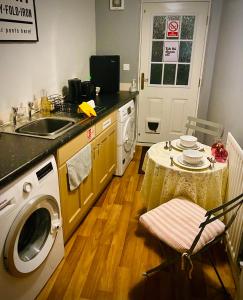 cocina con fregadero y lavadora en Modern ground floor apartment with free parking very near centre en Ripon