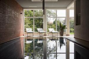 a room with chairs and a reflection in the water at Rock&Chill Hotel Falter in Drachselsried
