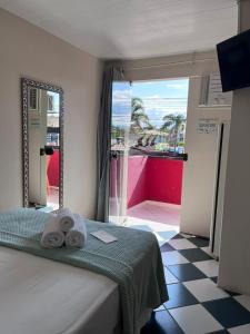 a bedroom with a bed with towels on it at Morada da Marta in Guarda do Embaú