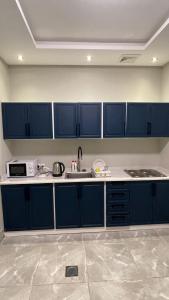 eine Küche mit blauen Schränken und einem Waschbecken in der Unterkunft درة العروس فيلا بشاطئ رملي خاص in Durrat Al-Arus
