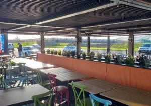 eine Terrasse mit Tischen, Stühlen und Autos auf einem Parkplatz in der Unterkunft MV18 Park Holidays, St Osyth Beach no smoking self catering holiday in Saint Osyth