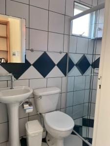 a bathroom with a toilet and a sink at Morada da Marta in Guarda do Embaú