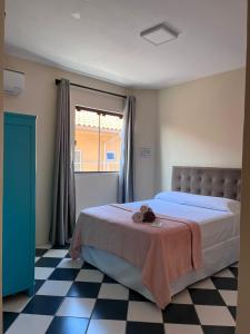 1 dormitorio con 1 cama y suelo a cuadros en Morada da Marta, en Guarda do Embaú
