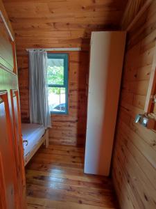 a room with a bed and a window in a log cabin at Lime tree houses in Beldibi