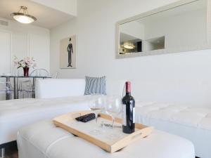 een woonkamer met een witte bank en wijnglazen bij Hollywood Take 2! 1-Bedroom with Balcony & VIEWS! in Los Angeles