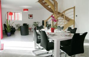 a dining room with a white table and black chairs at Stunning Home In Dourdain With 3 Bedrooms And Wifi in Dourdain
