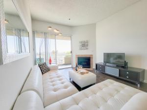 een woonkamer met een witte bank en een tv bij Hollywood Take 2! 1-Bedroom with Balcony & VIEWS! in Los Angeles