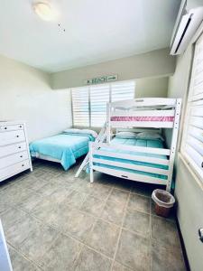 Un dormitorio con dos literas en una habitación. en 2-BR Modern Oceanfront Apt Steps from Playa Sucia, en Cabo Rojo