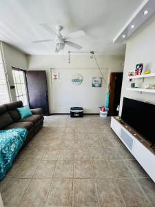 ein Wohnzimmer mit einem Sofa und einem Flachbild-TV in der Unterkunft 2-BR Modern Oceanfront Apt Steps from Playa Sucia in Cabo Rojo