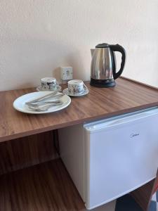 uma mesa com duas chávenas e uma chaleira de chá em Morada da Marta em Guarda do Embaú