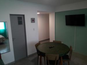ein Zimmer mit Tisch und Stühlen und einem Fernseher in der Unterkunft Dpto Olavarria in Mar del Plata