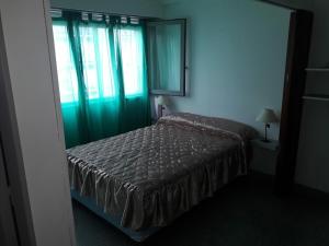 1 dormitorio con 1 cama en una habitación con ventana en Dpto Olavarria en Mar del Plata