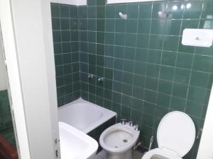 ein grün gefliestes Badezimmer mit Toilette und Waschbecken in der Unterkunft Dpto Olavarria in Mar del Plata
