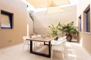 ガラチコにあるGarachico Homes - LA CASA DE VICTORIAのテーブルと白い椅子のあるダイニングルーム