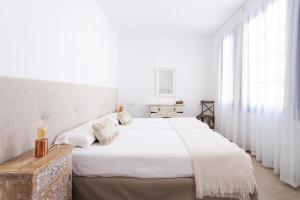 a white bedroom with two beds and windows at Garachico Homes - LA CASA DE VICTORIA in Garachico