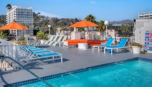 een zwembad met ligstoelen en parasols bij Hollywood Take 2! 1-Bedroom with Balcony & VIEWS! in Los Angeles