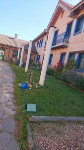 un edificio con columnas en el césped junto a un edificio en ALBERGUE peregrinos CASAFLOR en Murias de Rechivaldo