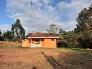 una pequeña casa sentada en la parte superior de un campo de tierra en Morada Jaguary en Camanducaia