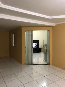 a living room with a door and a television at Casa Park Massangano in Petrolina