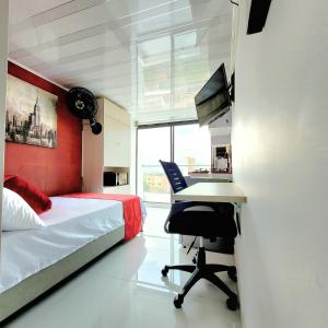 1 dormitorio con 1 cama y escritorio con ordenador en 703 Hermoso Apartasuite cerca al barrio Laureles, en Medellín