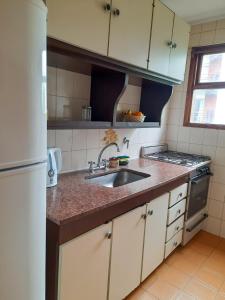 a kitchen with a sink and a stove at Departamento 2 amb con 1 dormitorio por Plaza Mitre in Mar del Plata