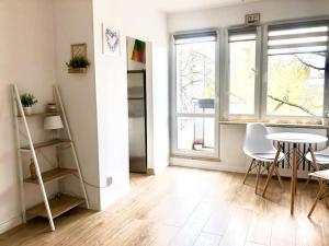 ワルシャワにあるprzytulne mieszkanieのテーブルと椅子、窓が備わる客室です。