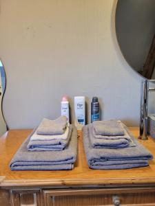 a wooden counter with towels and products on it at Escale Chambre d'hôtes Au coeur du vieux Profondeville entre Namur et Dinant in Profondeville