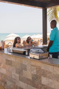 Elite Residence & Aqua Park في العين السخنة: مجموعة من الناس يجلسون في حانة على الشاطئ