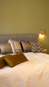 Elle comprend un grand lit blanc avec des oreillers. dans l'établissement סיני 48 מלון דירות בוטיק, à Vered Yeriho