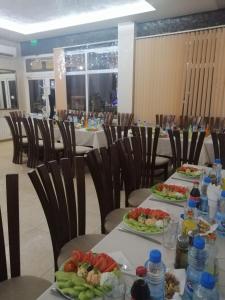 uma sala de jantar com duas mesas com pratos de comida em Червената къща em Perushtitsa
