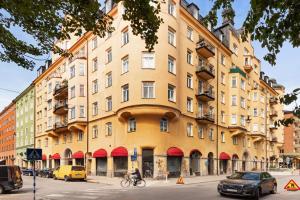 a large yellow building on a city street with cars at Apartment in central Stockholm in Stockholm