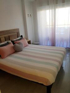 卡拉代法恩斯特拉的住宿－HR PARADISE CALA DE LA VILA JOIOSA，一间卧室配有一张大床,提供粉色和紫色枕头