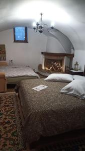 a bedroom with two beds and a fireplace at Ξενώνας Άνθεμις in Levidi