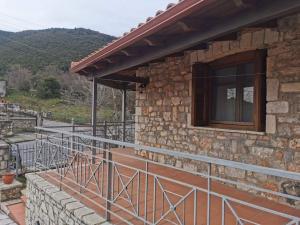 a stone house with a balcony and a window at Ξενώνας Άνθεμις in Levidi
