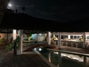 un complejo nocturno con piscina y sombrillas en Solwata House, On the Water Sleeps 6, en Port Vila