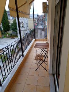 einen Balkon mit einem Tisch und Straßenblick in der Unterkunft Central Apartment Ioannina in Ioannina