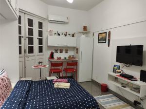 1 dormitorio con 1 cama y cocina con barra. en Charmoso Studio Ipanema, en Río de Janeiro