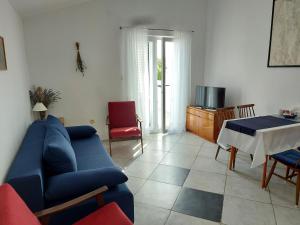 Vila Kraljica في مالينسكا: غرفة معيشة مع أريكة زرقاء وطاولة