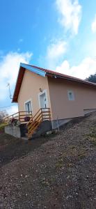 une petite maison avec une terrasse couverte et un escalier dans l'établissement Kuća Zdravka Goč, à Goč
