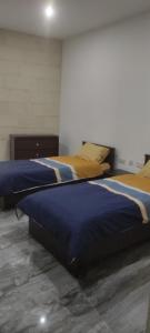 a bedroom with two beds with blue and yellow sheets at L-irdoss in Vittoriosa