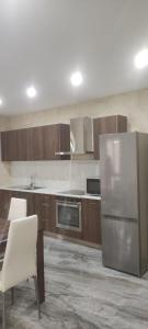 a kitchen with a stainless steel refrigerator and wooden cabinets at L-irdoss in Vittoriosa