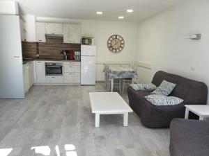 a living room with a couch and a table and a kitchen at Domaine de Bordaberry in Urrugne