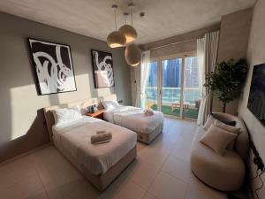 um quarto de hotel com duas camas e um sofá em Lovely Dubai Eye & Sea View, 3 mints to beach no Dubai