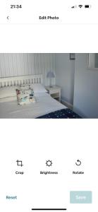 a screenshot of a bedroom with a bed and a website at Cosy seaside cottage in Criccieth