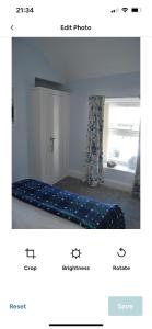a bedroom with a bed in a room with a window at Cosy seaside cottage in Criccieth