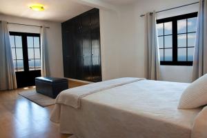 une chambre avec un grand lit et deux grandes fenêtres dans l'établissement Casa Hugo, à Tías 10 autres photos