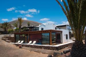 une maison avec une piscine et quelques palmiers dans l'établissement Casa Hugo, à Tías