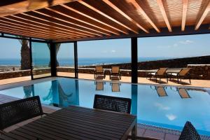 - une piscine avec une table et des chaises dans l'établissement Casa Hugo, à Tías