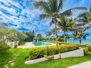 a villa with a swimming pool and palm trees at Villa Sea Haven at Orange Hill Beach - Private Pool in Nassau